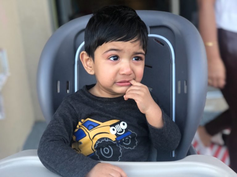 Child with toothache pointing to his tooth