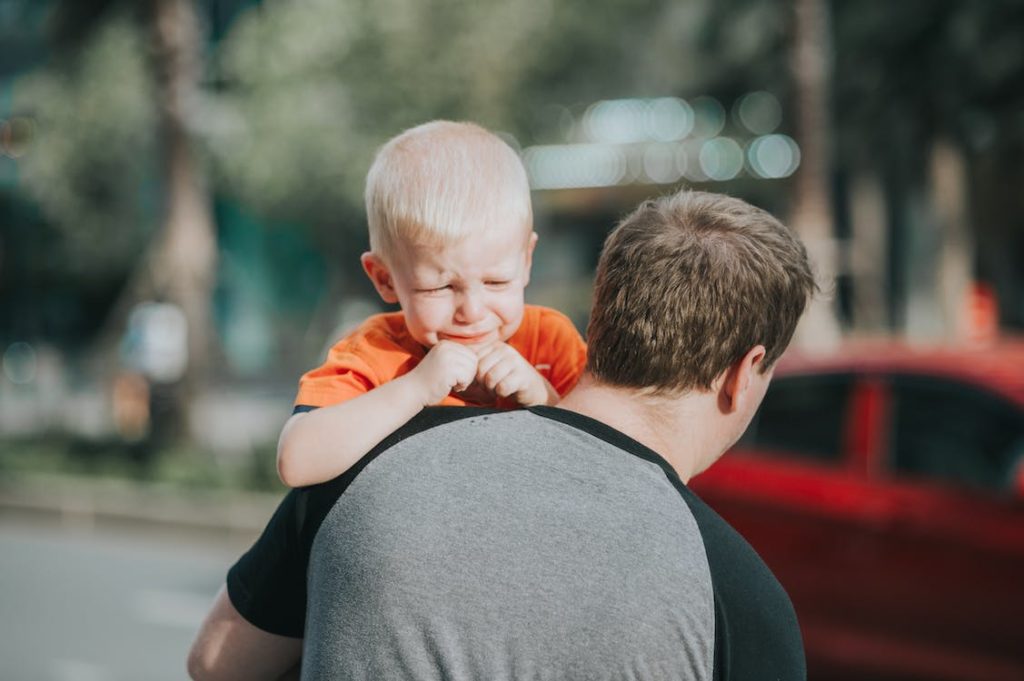 Man carrying a crying child