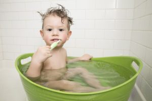 TODDLER BRUSHING TEETH IN THE BATHTUB